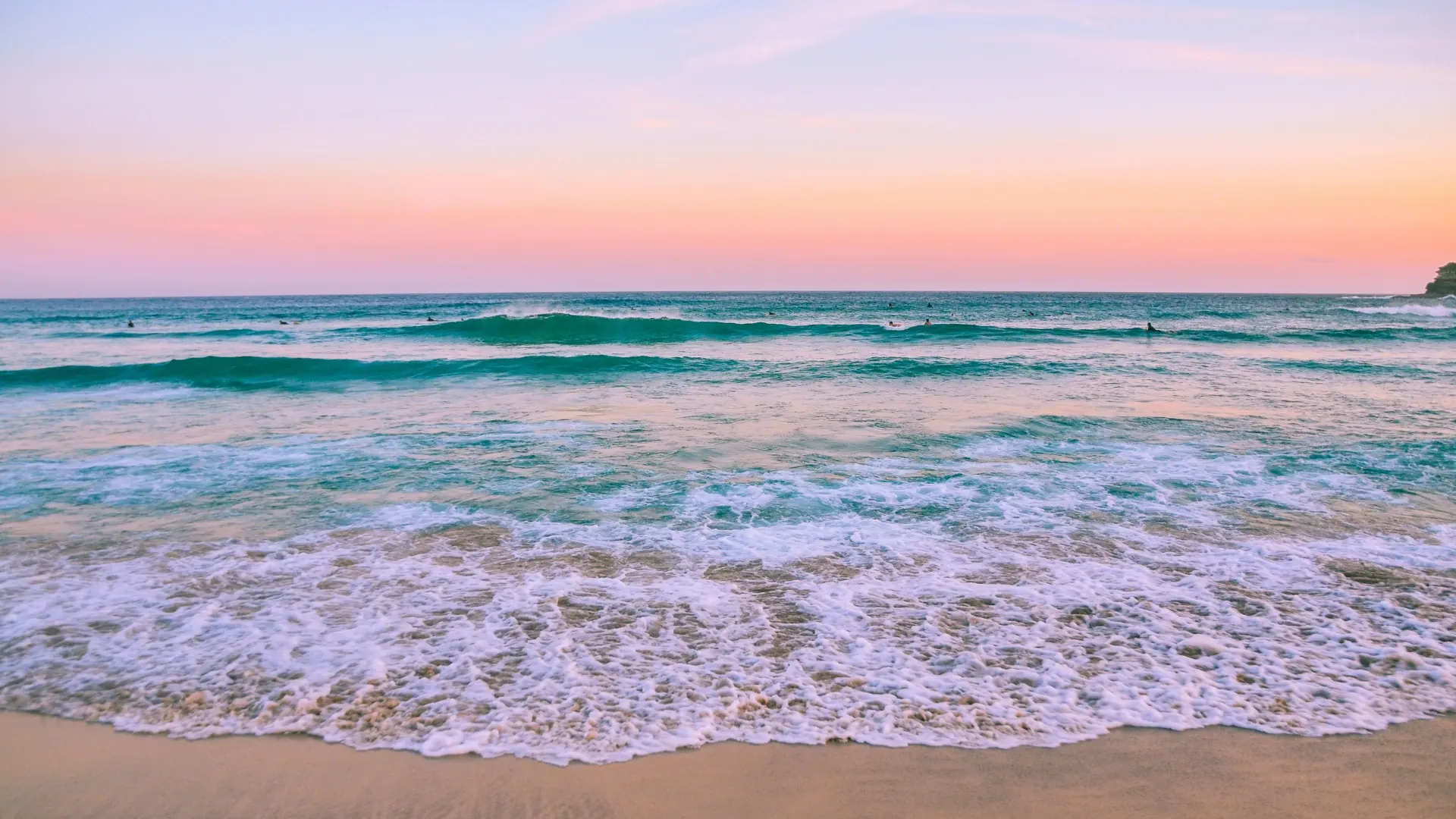 Coucher de soleil pastel sur la plage, vagues et écume